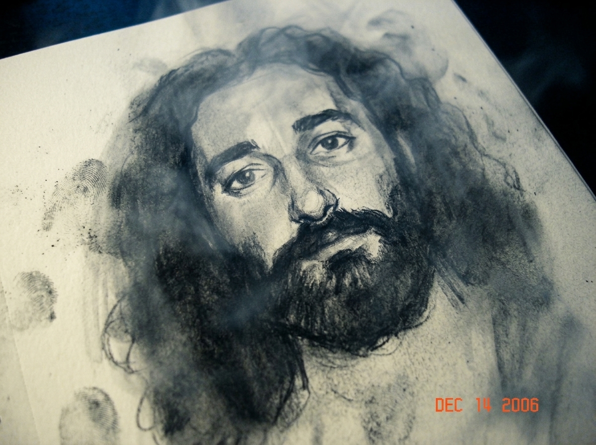 a close up of charred, smudged pencil drawing on thick textured paper, showing the vague charcoal outline of a small face covered in smoke and shadow, with smudged fingerprints next to it