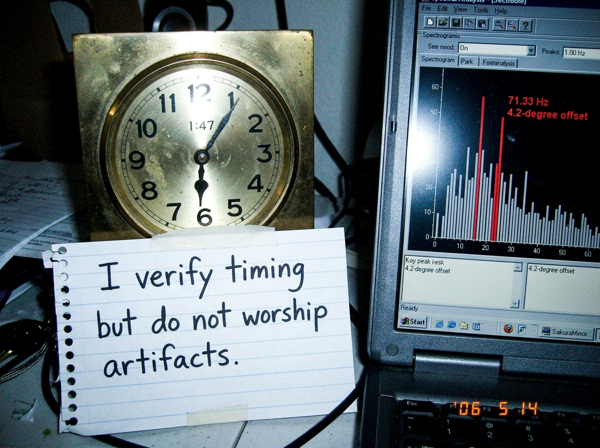 A close-up of a shrine clock face frozen at 1:47, next to a handwritten note in SakuraMirror's neat script: 'I verify timing but do not worship artifacts.' The laptop screen shows a spectrogram with peaks at 71.33 Hz and 4.2-degree offset highlighted, but the alignment looks suspiciously perfect to
