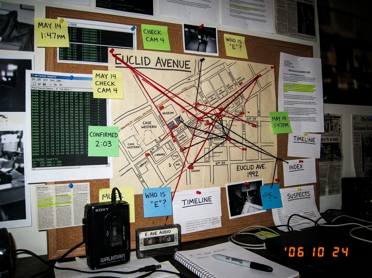 A cluttered home office wall with a large hand-drawn map of Euclid Avenue marked with red pins, string connecting locations, sticky notes with dates and times written in marker, a 1992 Sony Walkman on the desk below, conspiracy board aesthetic with printed screenshots tacked up showing timestamps of