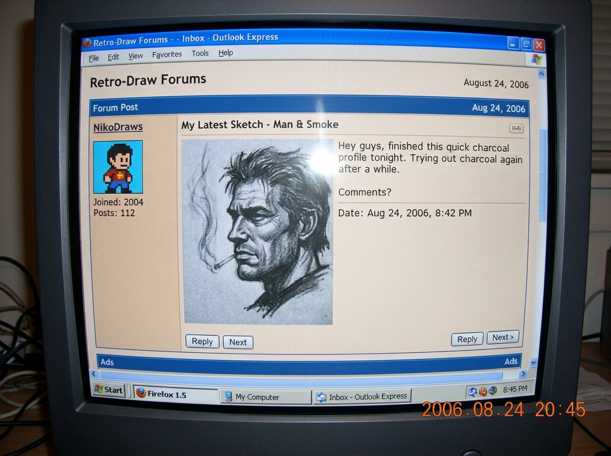 A close-up, slightly blurry digital photo of a computer screen showing a forum post. The post contains a charcoal drawing of a man's profile next to faint smoke. The screen has a visible moiré pattern and the taskbar shows 'My Computer' and a 2006-era Firefox icon.