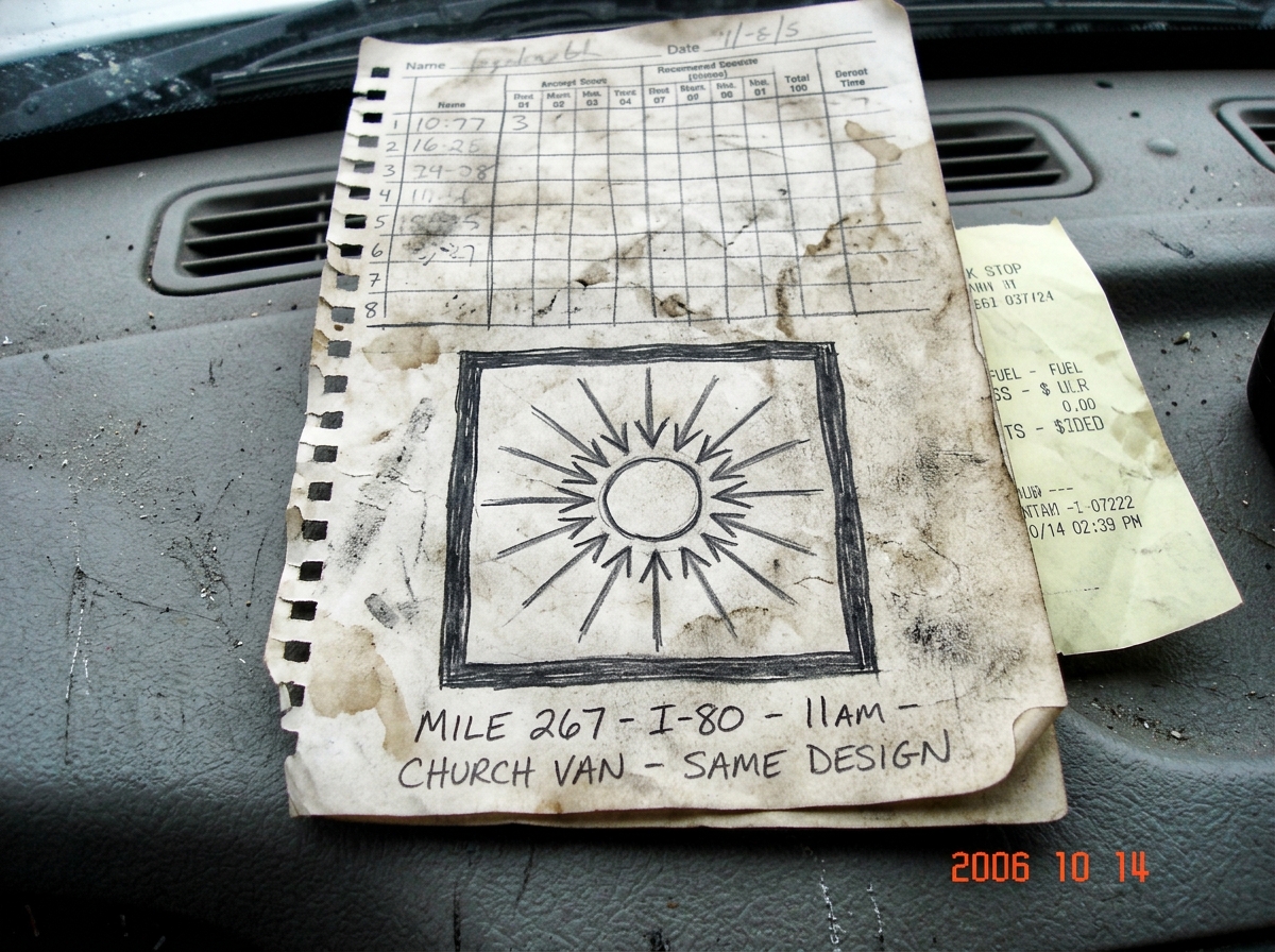 A torn page from a truck driver's logbook, photographed on a dashboard. A rough but careful pencil sketch of a sun symbol with rays pointing inward toward a small circle, surrounded by a thick border. The handwriting below reads 'Mile 267 - I-80 - 11am - CHURCH VAN - SAME DESIGN' in all caps. The pa
