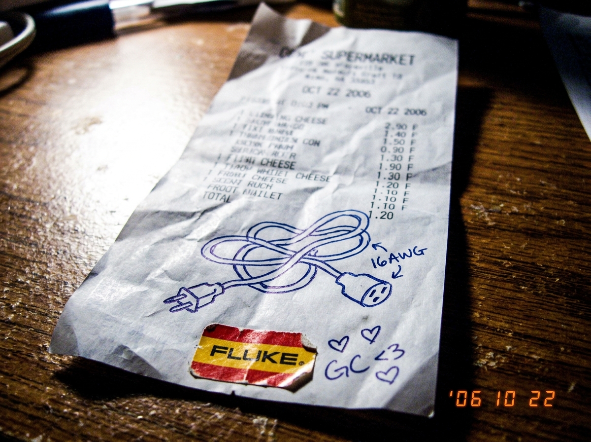 A crumpled cheese receipt with a doodle of a 16awg extension cord drawn in pen, alongside a tiny Fluke multimeter sticker and three little hearts labeled 'GC <3 <3'