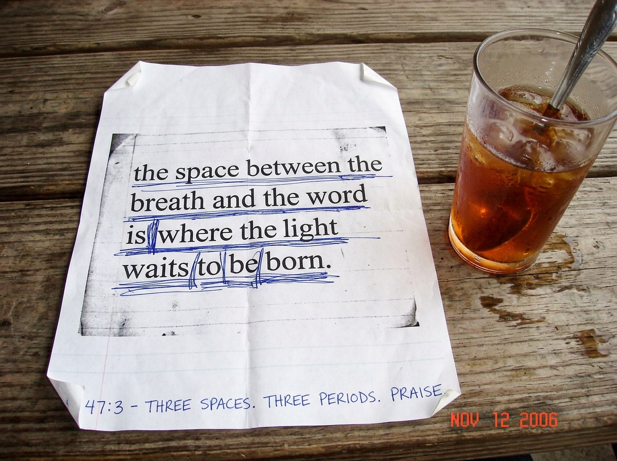 A crumpled, dog-eared printout of text showing repeated underlines in blue ballpoint pen on a line that reads 'the space between the breath and the word is where the light waits to be born.' In the bottom margin, handwritten in careful block letters: '47:3 - THREE SPACES. THREE PERIODS. PRAISE.' The
