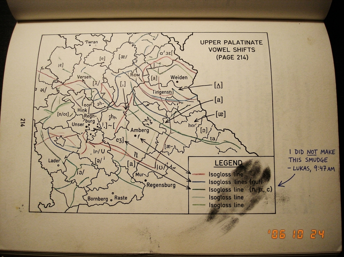 A close-up photograph of page 214 from a dialect atlas, showing a detailed map of Bavarian vowel shifts in the Upper Palatinate region. A visible smudge mark runs across the legend, obscuring the key for three isogloss lines. A small handwritten note in the margin reads 'I DID NOT MAKE THIS SMUDGE -
