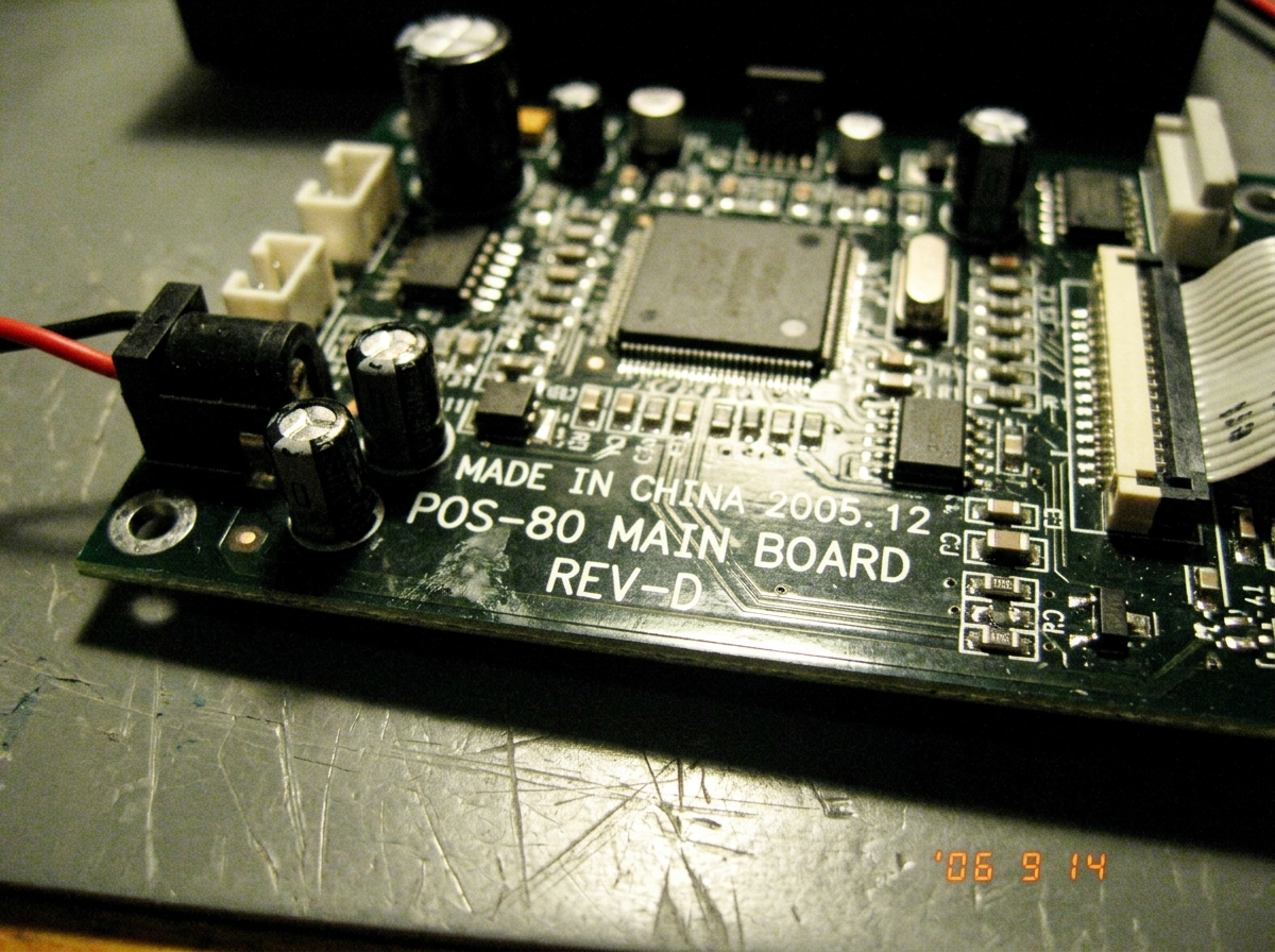 A close-up photo of a POS-80 thermal printer mainboard with visible silkscreen text showing 'REV-D'