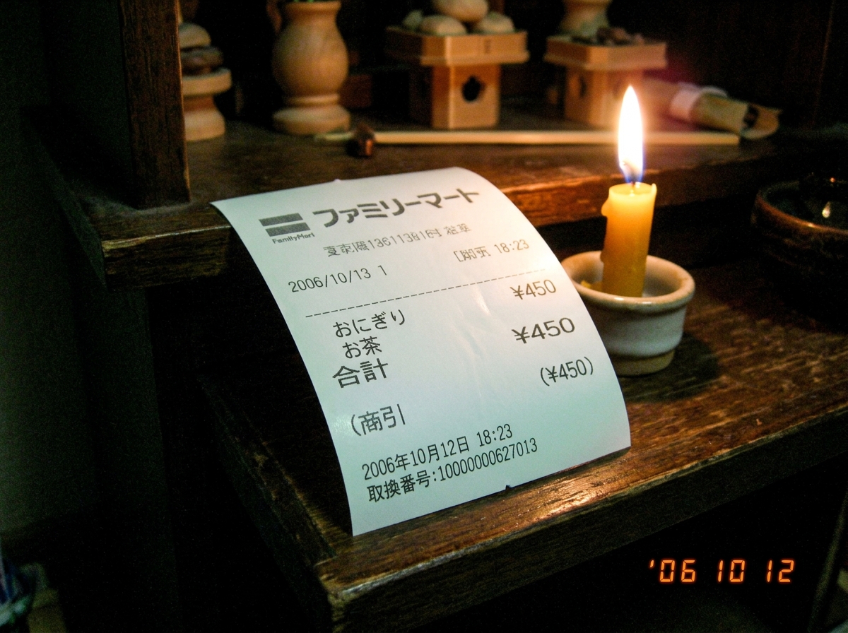 A clean thermal paper receipt from a Japanese kiosk, slightly curled at the edges, with a faint greenish glow visible along the top edge under dim light. The paper shows a faint 47Hz grid pattern when held at an angle, and the faint outline of kanji characters that might be a timestamp or location c