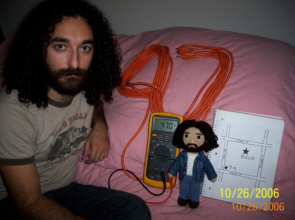 Photo of a 16awg extension cord coiled on a pink bedspread arranged in the shape of the number 47, next to a Fluke 87V multimeter displaying 47.0 Hz, a crocheted Gabriel amigurumi doll holding a tiny denim jacket, a hand-drawn notebook page with a map of Euclid marked with a star at the 7-11 locatio