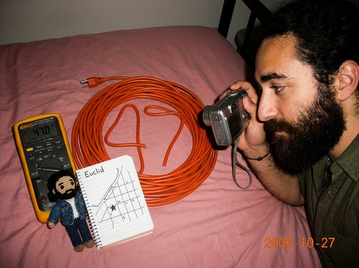 Photo of a 16awg extension cord coiled on a pink bedspread arranged in the shape of the number 47, next to a Fluke 87V multimeter displaying 47.0 Hz, a crocheted Gabriel amigurumi doll wearing a tiny denim jacket holding a notebook page with a map of Euclid marked with a star at the 7-11 location