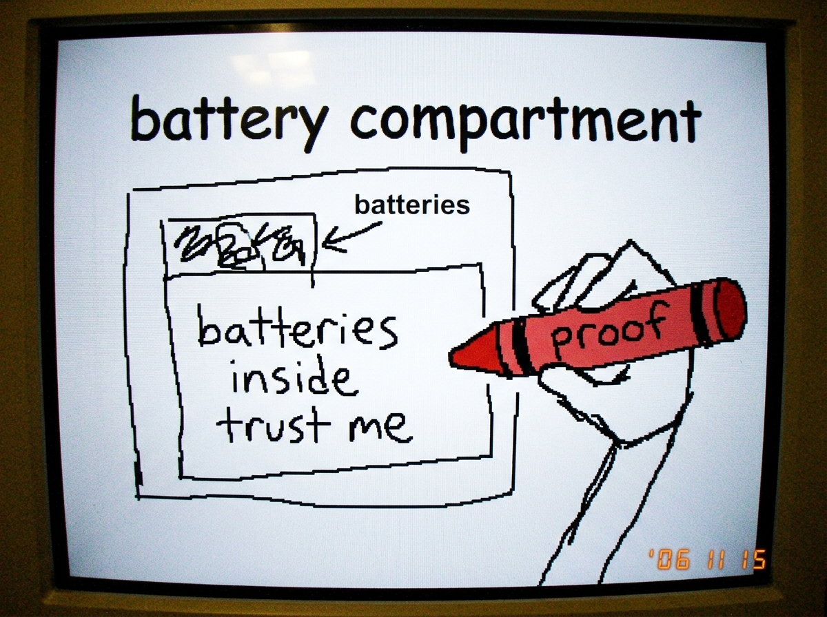 A grainy photo of the inside of a 'battery compartment' - drawn poorly in MS Paint with a stick figure hand holding a crayon labeled 'proof'. Scribbled text reads 'batteries inside trust me' in a wobbly font.