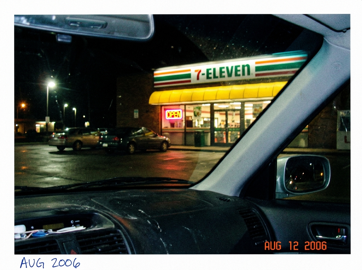 A blurry camera phone photo taken from inside a car at night, showing a 7-11 storefront in Euclid, Ohio. The store has a glowing red 'OPEN' sign and a yellow awning. There is a handwritten date 'AUG 2006' in blue ink on the bottom corner of the photo.