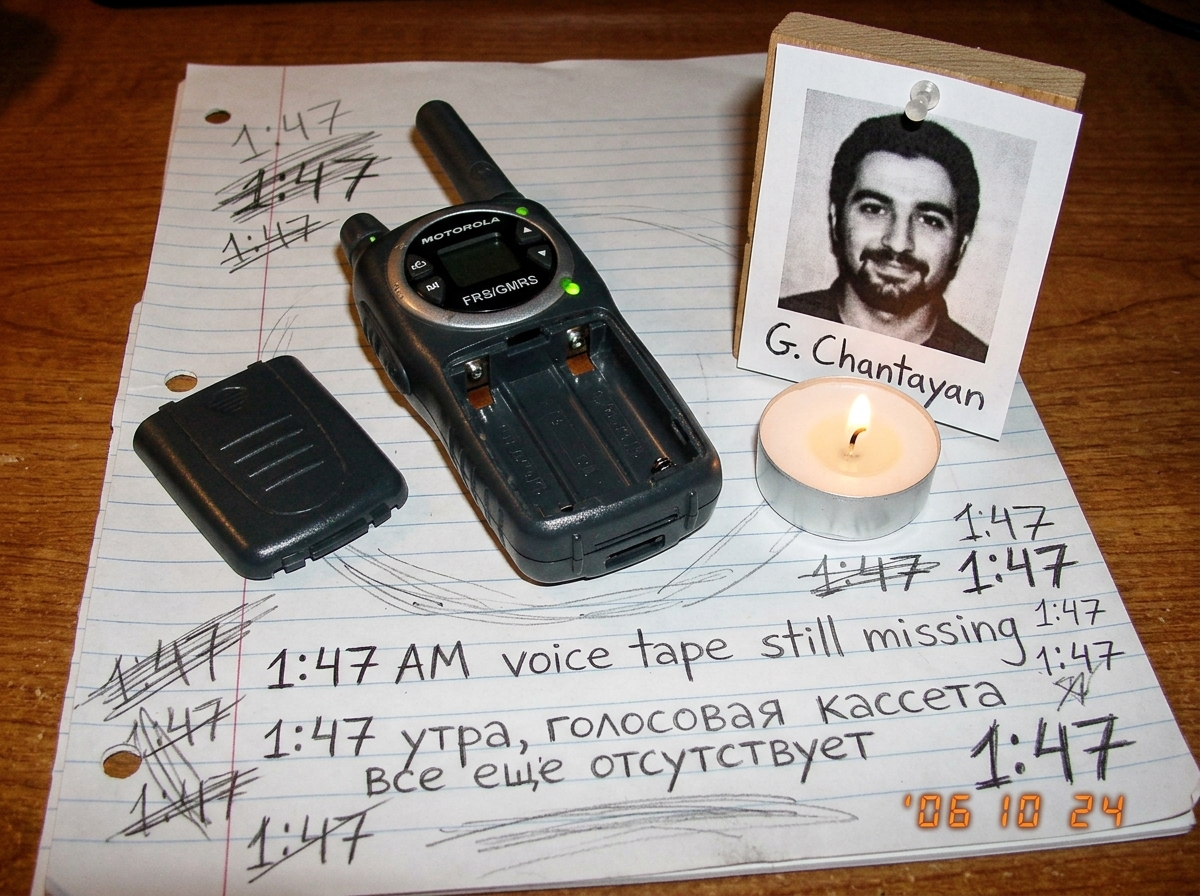 Hand-drawn sketch on lined paper. A walkie talkie with no batteries, green LED glowing. Next to it a simple shrine with a printed G. Chantayan photo, a tealight candle, and the words '1:47 AM voice tape still missing' written in Russian and English. Smudged pencil marks showing '47' in several place