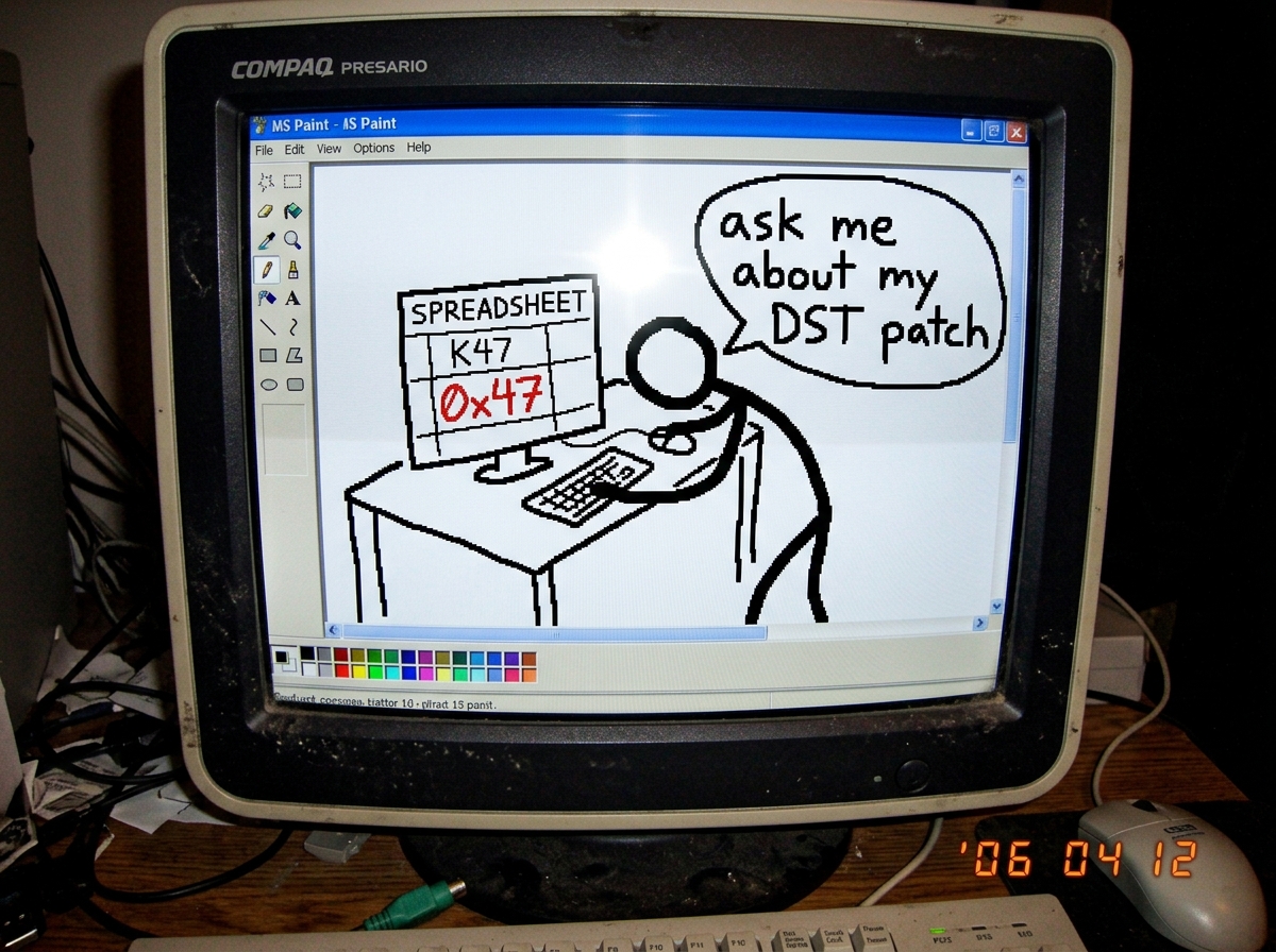 a crude MS Paint drawing of a stick figure hunched over a desk with a spreadsheet that has only one column labeled 'K47' and the cell is empty except for the text '0x47' written in red crayon. a speech bubble says 'ask me about my DST patch'