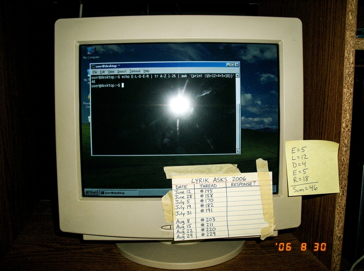 A screenshot of a terminal window on a dark desktop showing the output of 'echo E-L-D-E-R | tr A-Z 1-26 | ...' with a hand-calculated sum of 46 scribbled on a sticky note beside the monitor. The monitor bezel has a small index card taped to it showing a hand-drawn row/column grid tracking Lyrik's ni