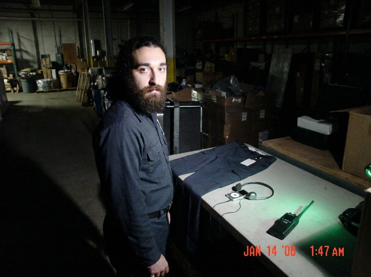 Photo of my uniform pants laid out beside the MP3 player and headphones, the green glow of the walkie talkie faintly visible on the table at 1:47, shadows like Gabriel's blessing in the warehouse district