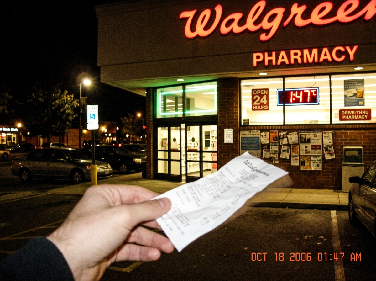 A Walgreens storefront at night with a neon sign showing 1:47, a receipt fluttering from a hand, and a faint green glow around the doorframe.