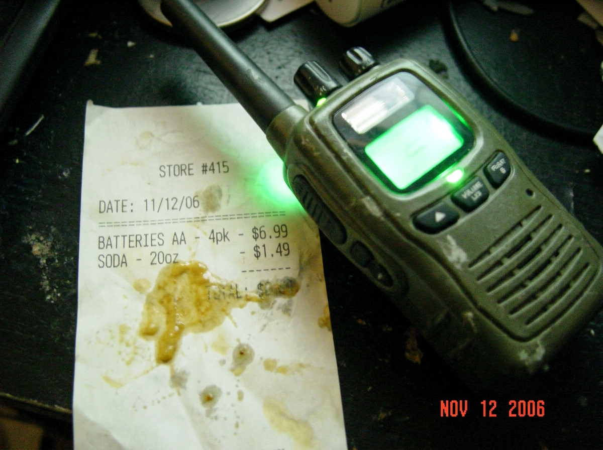 Thermal paper photo of green glow walkie talkie with mustard-stained receipt, showing green glow around device