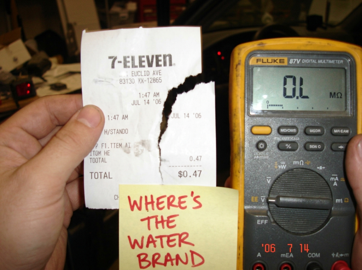 A blurry phone camera photo of a 7-Eleven receipt from Euclid Avenue. The receipt is partially torn, showing a timestamp of 1:47 AM but the item names are ripped off leaving only the total of $0.47 visible. The receipt is held next to a Fluke 87V display showing OL. A handwritten sticky note at the