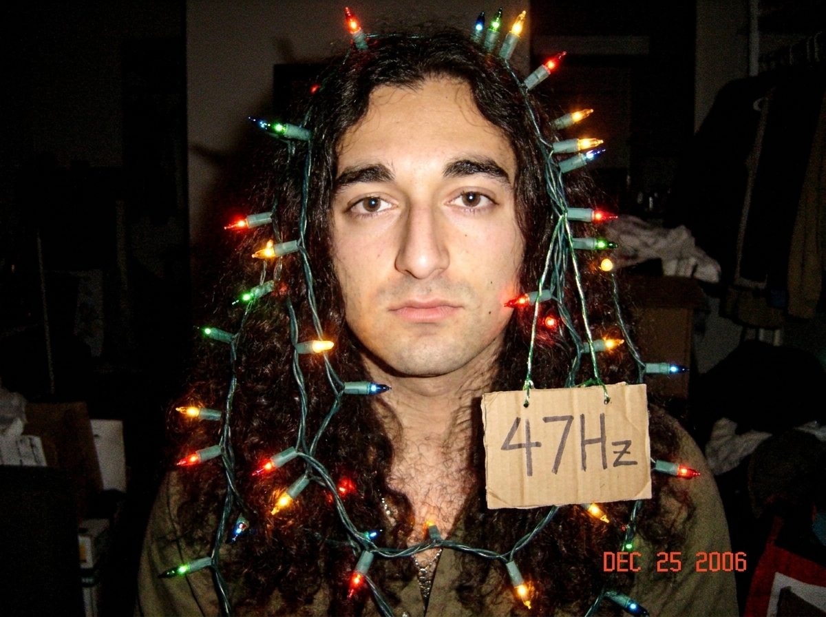 A still from the Lost season 4 finale showing Denver's long, wavy hair illuminated by dramatic lighting, Photoshopped to look like a Gabriel Chantayan shrine draped in multicolored Christmas lights with a tiny '47Hz' sign hanging from the strands.