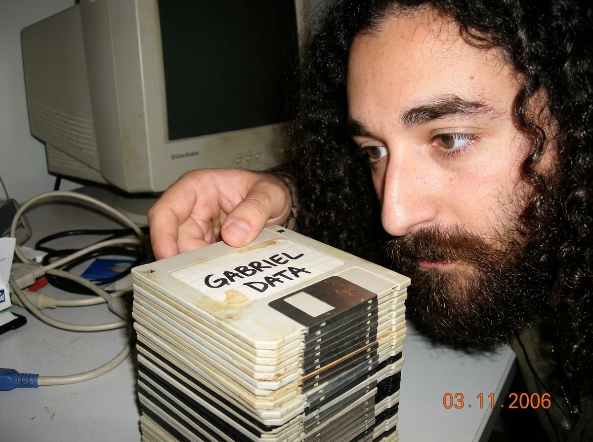 A close-up of a stack of 47 floppy disks, some slightly warped and discolored, with handwritten labels in black sharpie reading 'GABRIEL DATA'. The disks are slightly out of focus, emphasizing the labels and the wear on the plastic sleeves.