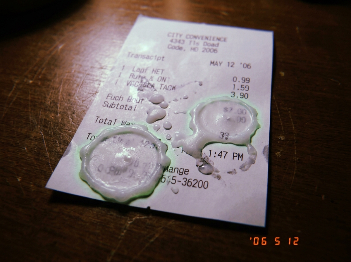 Thermal paper receipt showing candle wax hardening in circular patterns at exactly 1:47 timestamp, with faint green glow smudge near the wax edge