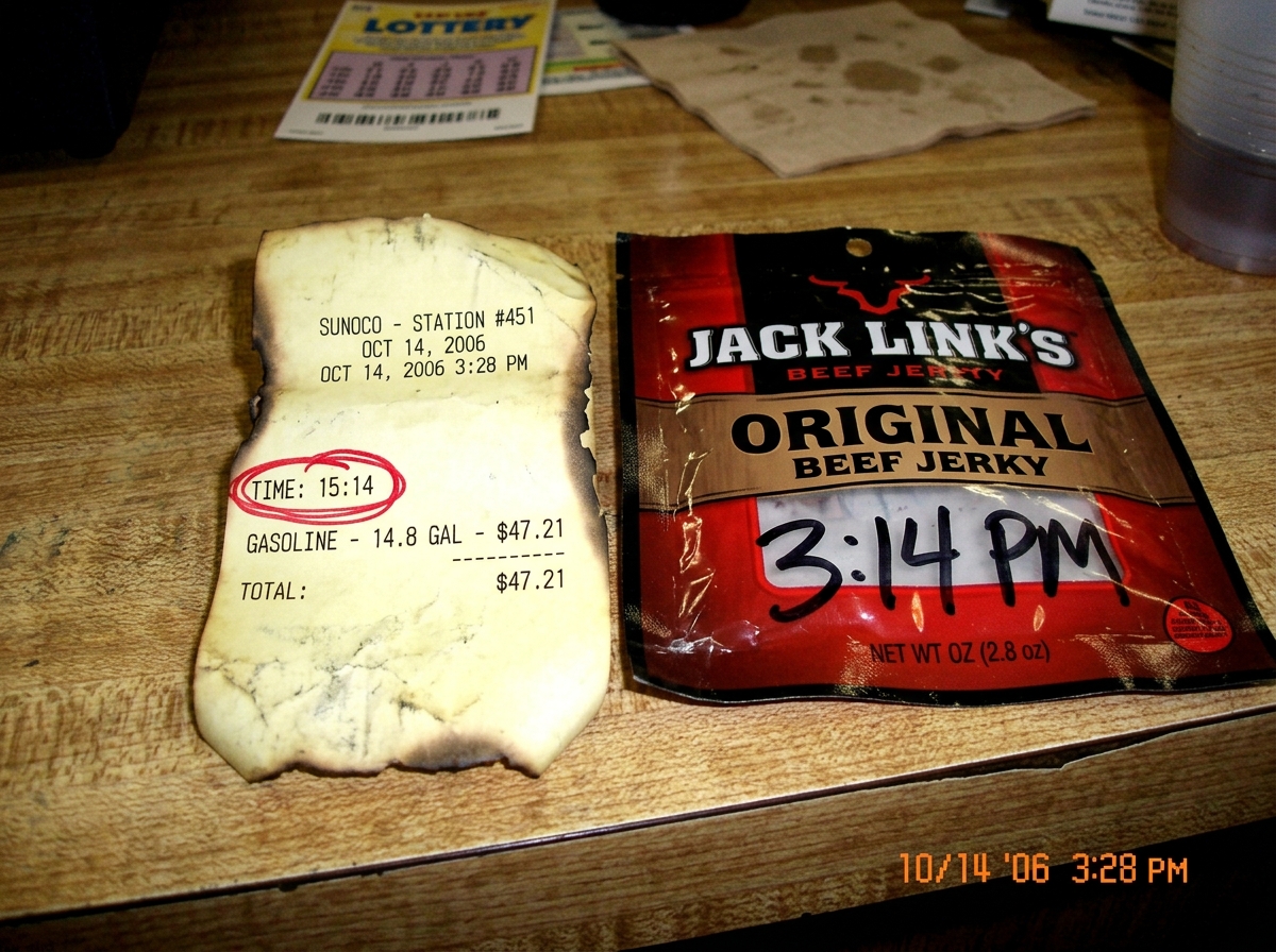 A gas station receipt with the time stamp '3:14' circled in red pen, next to a beef jerky wrapper with the same time written on it in Sharpie. The receipt paper is curling at the edges, showing signs of thermal decay.