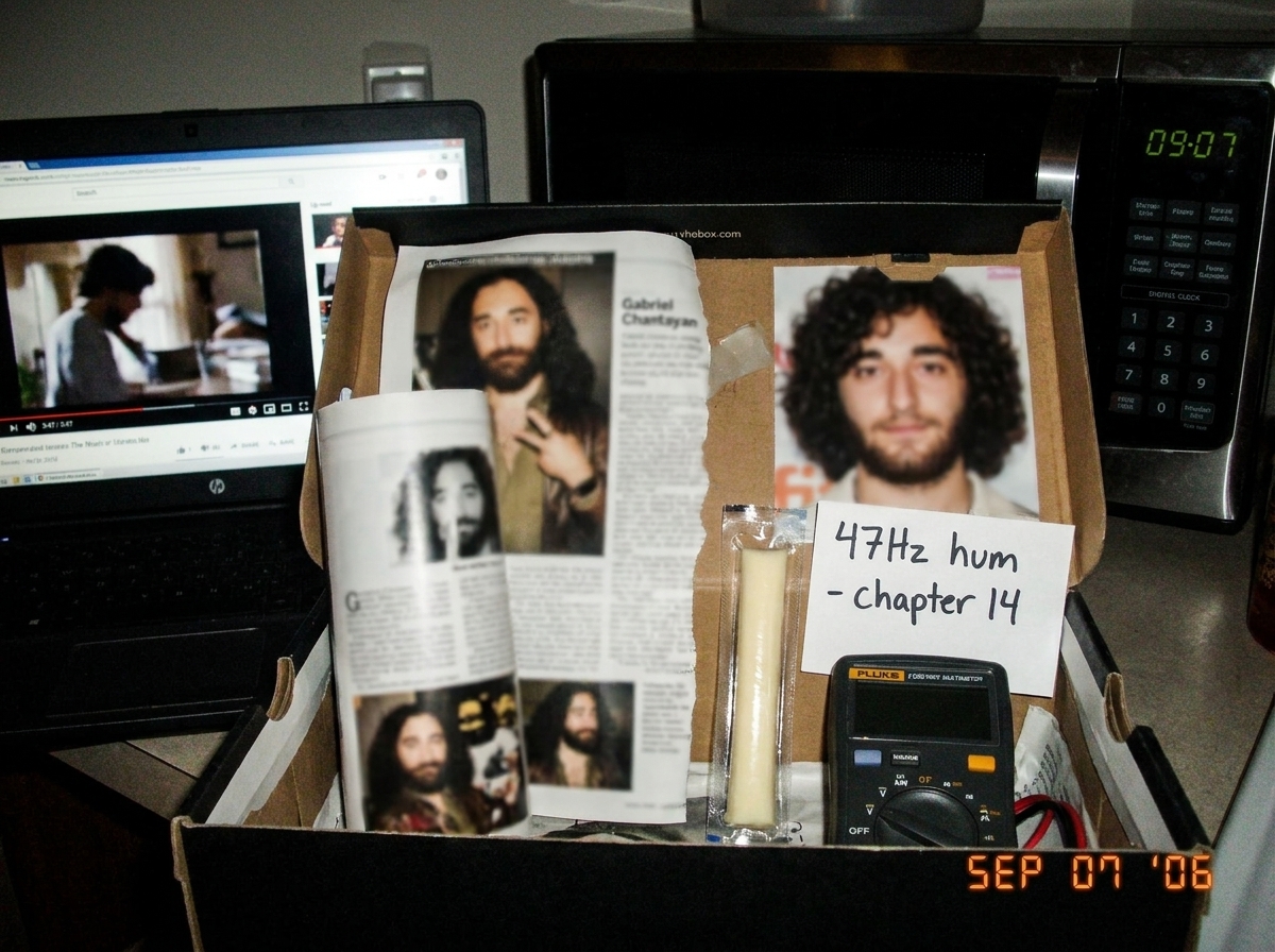 My shoebox altar with Gabriel magazine clippings, blurry teen magazine photo, string cheese, tiny Fluke multimeter, handwritten note '47Hz hum - chapter 14', a laptop showing a paused frame at 3:47, and a microwave clock reading 09-07