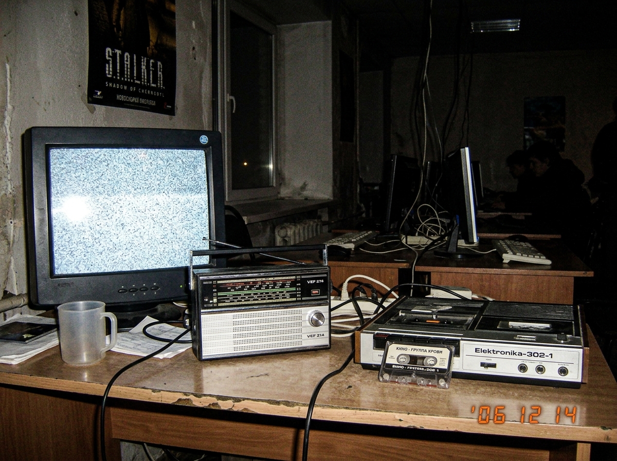 Grainy night photo from Novosibirsk internet cafe showing Russian analog radio and cassette recorder on table, static on screen, no green glow, just empty winter darkness