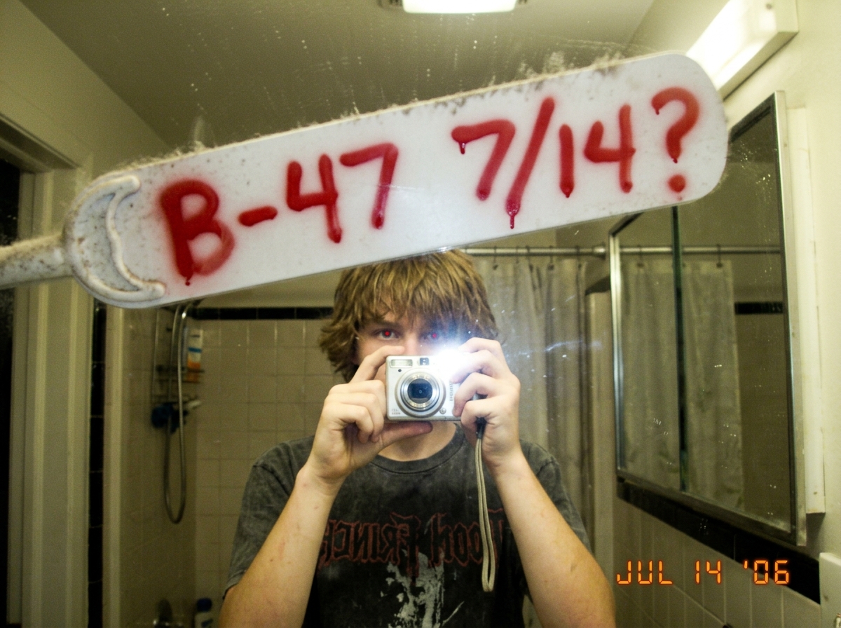 A blurry photo of a white ceiling fan blade, spay-painted with 'B-47 7/14?' in red spray paint, bathroom mirror selfie style