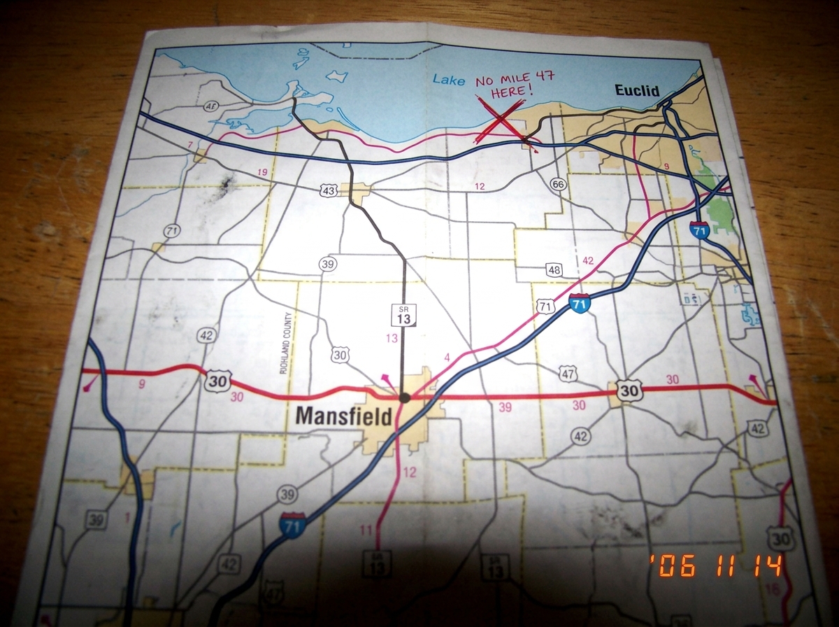 A printed page from the 2004 Ohio Department of Transportation atlas showing SR 13 terminating at US 30 in Mansfield, with a red X drawn over the area where 'mile marker 47' supposedly exists near Euclid
