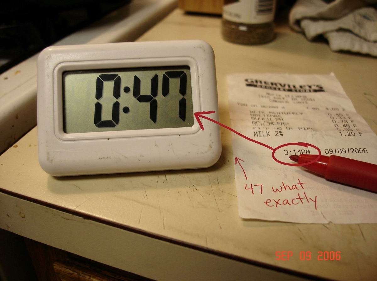 A blurry phone photo of a cheap digital kitchen timer sitting on a counter, its display reading 0:47. Next to it, a crumpled receipt for 'MILK 2%' dated 09/09/2006 - the same receipt Scribe posted. Someone has circled the time 3:14PM on the receipt and drawn a red arrow pointing to the timer's 0:47,