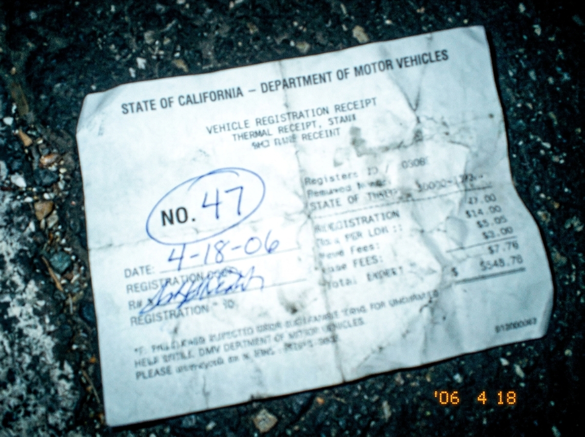 A crumpled DMV renewal receipt with 'NO. 47' circled in pen, taken on a shaky camera phone in a parking lot