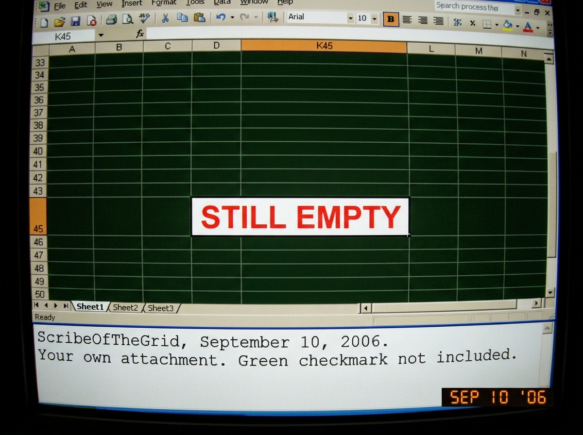 A screenshot of a spreadsheet cell K45 with the words 'STILL EMPTY' in red, bold, 24pt font. Below the cell, a caption in Courier New reads: 'ScribeOfTheGrid, September 10, 2006. Your own attachment. Green checkmark not included.' The background is a dark green grid pattern suggesting late-night spr