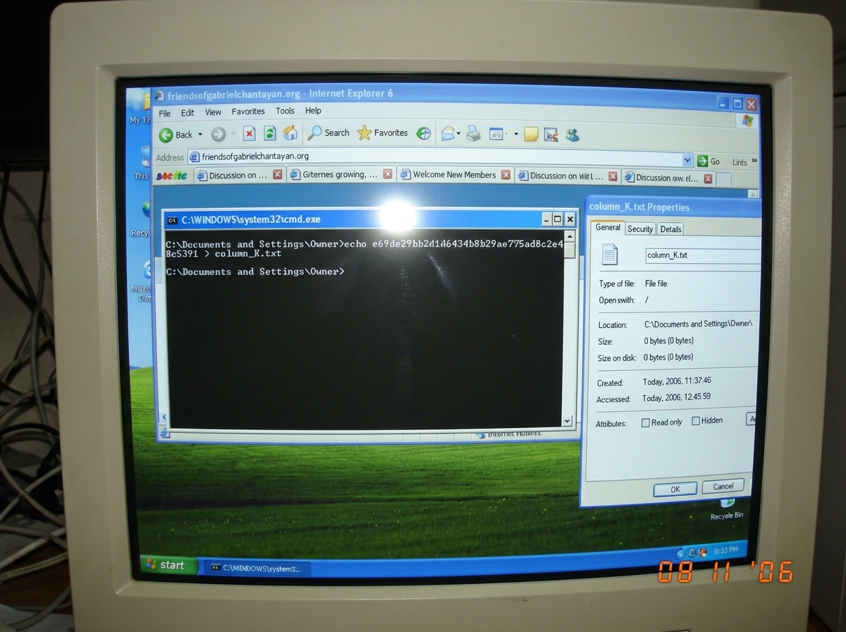 A screenshot of a Windows XP desktop showing a command prompt window with 'echo e69de29bb2d1d6434b8b29ae775ad8c2e48c5391 > column_K.txt' typed out, with the resulting file properties dialog open showing the file size as 0 bytes. The desktop background is the default XP green hills. Multiple forum ta