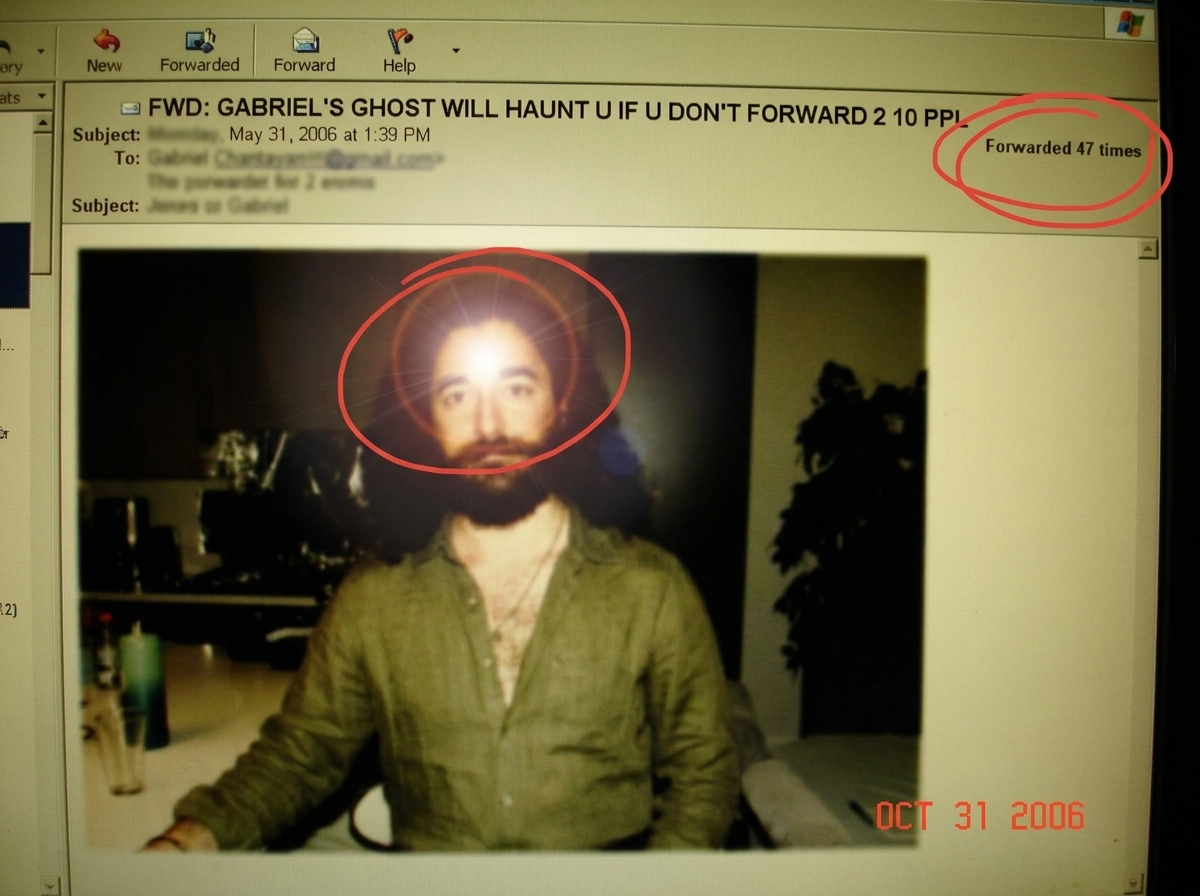 A grainy screenshot of a forwarded chain email titled 'GABRIEL'S GHOST WILL HAUNT U IF U DON'T FORWARD 2 10 PPL'. The email has a photoshopped lens flare over a blurry figure that looks like it was cut from a low-res jpeg of a man in a linen shirt. The forward bar shows it has been forwarded 47 time